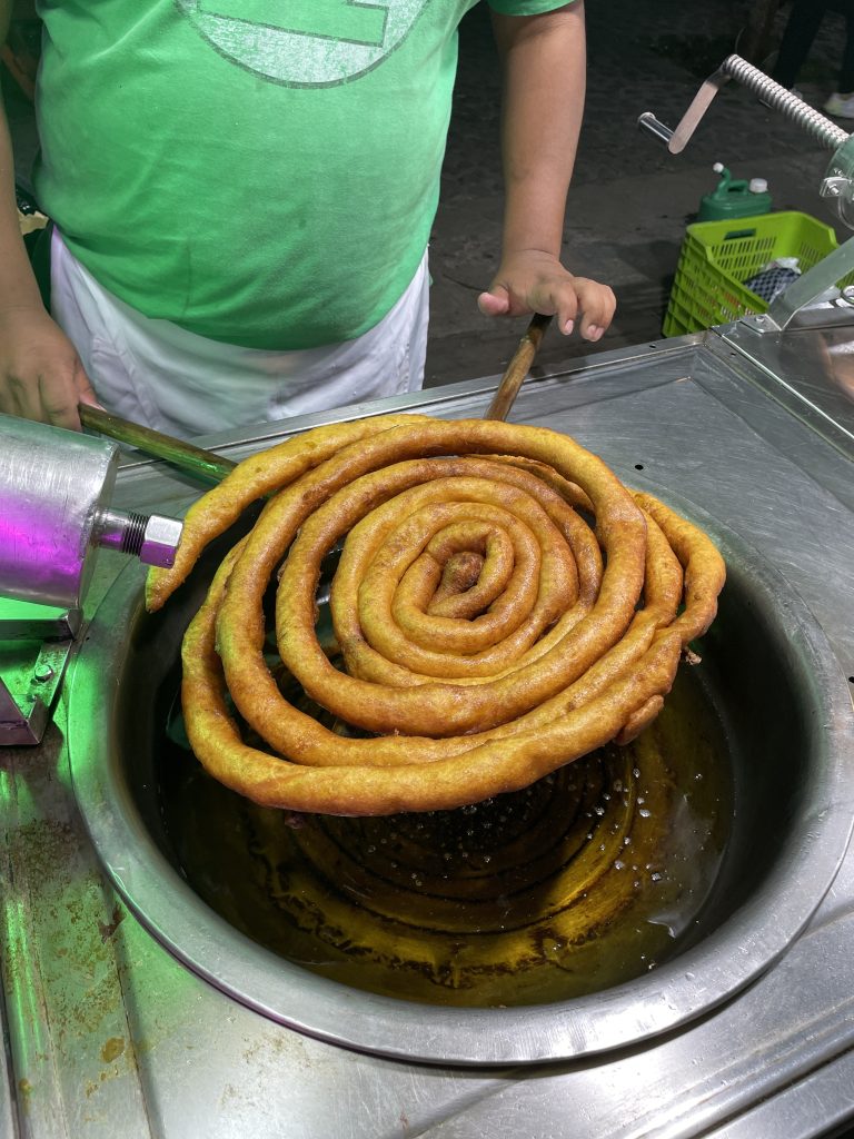 Ver el rollo de churro dorado, con ese aroma hipnotizante, más azucar o sirope de chocolate es verdaderamente irresistible. (Foto Michelle González) – SoyMigrante.com REVISTA Ver el rollo de churro dorado, con ese aroma hipnotizante, más azucar o sirope de chocolate es verdaderamente irresistible. (Foto Michelle González) – SoyMigrante.com REVISTA