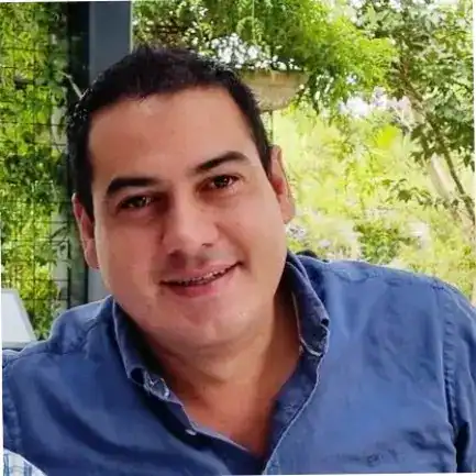 Fotografía de un hombre sonriendo en un entorno natural, representando temas de migración, comunidad y bienestar en el contexto de la revista SoyMigrante.com. – SoyMigrante.com REVISTA