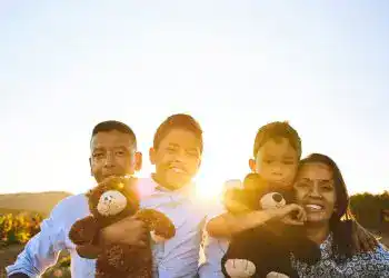 Familia multicultural disfrutando al atardecer, reflejando inmigración, integración y comunidad en la revista SoyMigrante.com REVISTA.