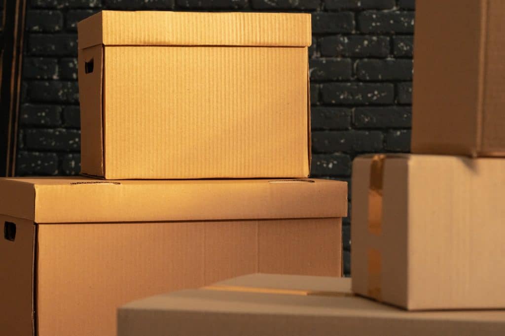 Cajas de cartón apiladas y listas para mudanza o almacenamiento, símbolo de migración y movimiento de personas y bienes. – SoyMigrante.com REVISTA