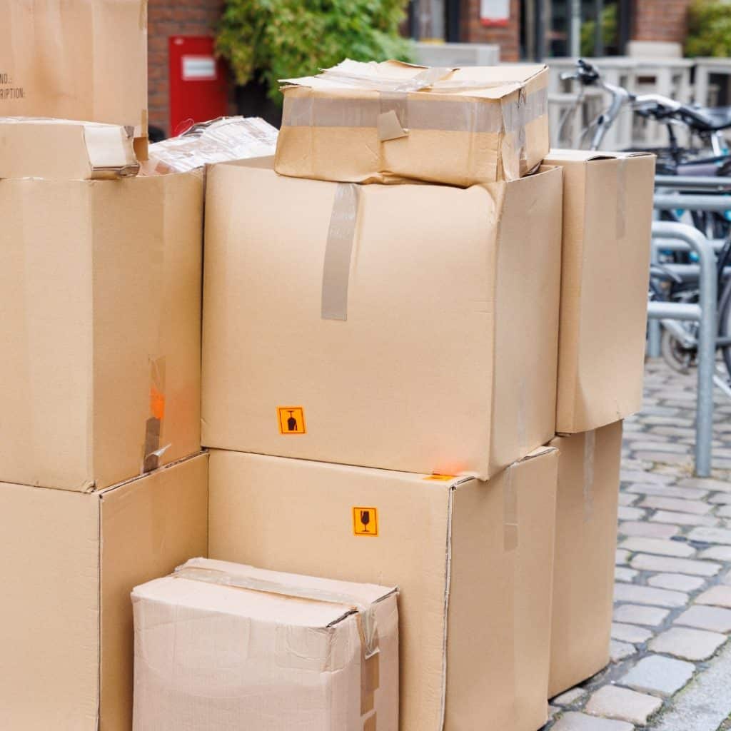 Contenedores de cartón para envíos y mudanzas en distribución logística en la calle. – SoyMigrante.com REVISTA