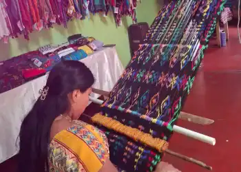 Coloridas textiles tradicionales mexicanas bordadas a mano en un mercado artesanal.