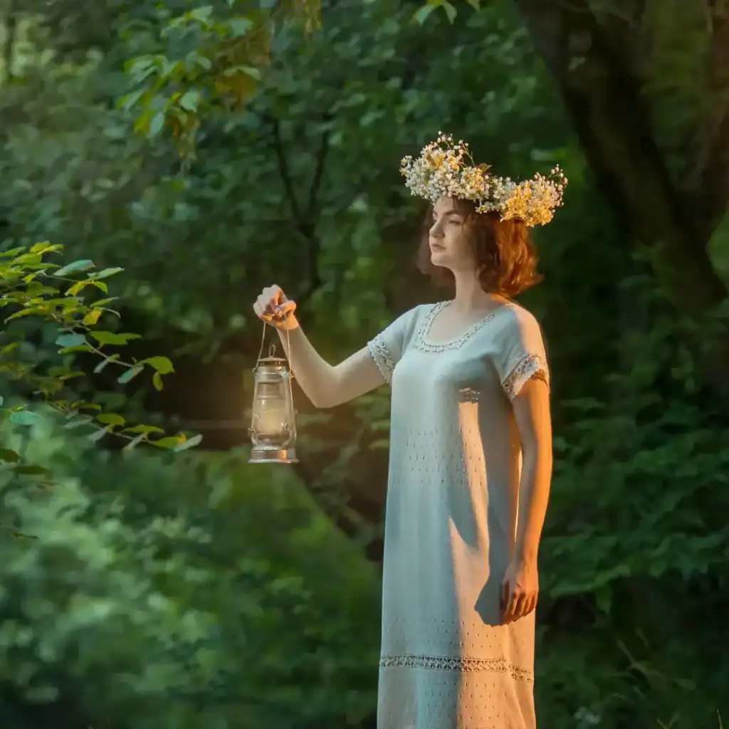 Un mujer con corona de flores sostenido una linterna en un bosque, simbolizando conexión con la naturaleza y espiritualidad. Perfecta para artículos sobre migración, cultura, bienestar y noticias relacionadas. – SoyMigrante.com REVISTA