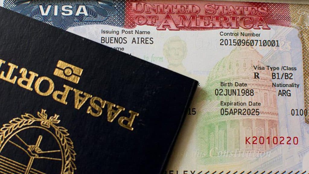 Pasaporte y visa americana sobre fondo de documentos de inmigración, representando migrantes y procesos de naturalización en EE.UU. – SoyMigrante.com REVISTA