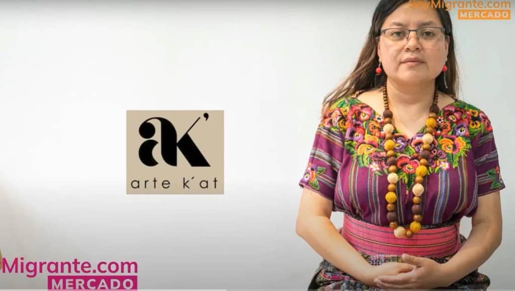 Artista indígena vestida con ropa tradicional y accesorios de colores vivos, en un video de Revista SoyMigrante.com en el que se destaca el arte k’at y la cultura indígena en contextos migratorios. – SoyMigrante.com REVISTA