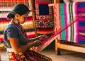 La mujer indígena teje coloridos textiles tradicionales en un taller de artesanías, resaltando la cultura, identidad y artesanía mexicana en la revista SoyMigrante.com REVISTA. – SoyMigrante.com REVISTA