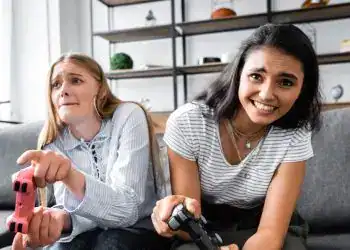 Videojuegos, jóvenes jugando en casa, gaming, diversión, entretenimiento para adolescentes, mujer y niña con mandos, cultura gamer, ocio digital, experiencia de juego, pantalla de videojuegos, ocio juvenil, comunidad gamer, diversión en interiores, videojuegos en familia.