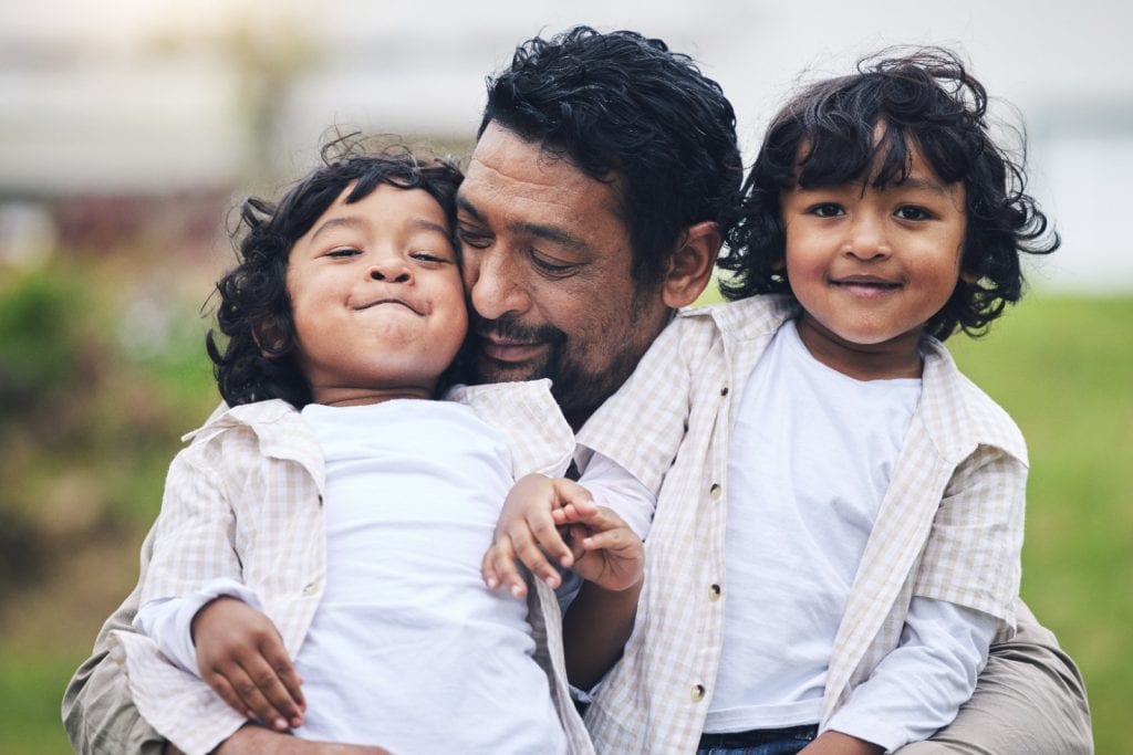 Padre con niños, amor familiar, alegría, diversidad, inmigrantes, inclusión, derechos de los migrantes, comunidad, apoyo, cultura latina, familia unida.