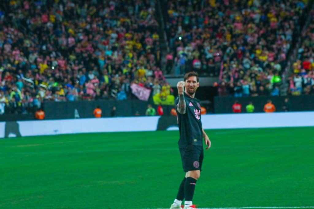 Futbolista celebrando en el campo con gran afluencia de público en las gradas, en un evento deportivo destacado.