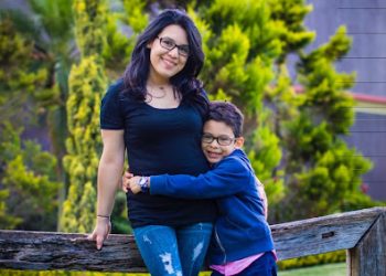 Padres e hijos sonrientes en un parque, destacando la importancia de la familia y la migración en la sociedad.