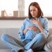 Dolor de pecho y malestar en mujer joven por posible problema cardíaco, en casa, ansiedad o estrés.