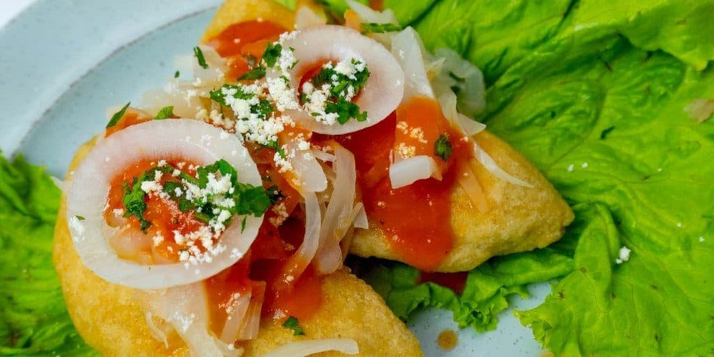 Sopes tradicionales mexicanos con ingredientes frescos, queso, salsa y verduras, perfectos para disfrutar de la gastronomía mexicana auténtica.