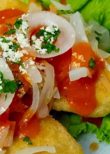 Sopes tradicionales mexicanos con ingredientes frescos, queso, salsa y verduras, perfectos para disfrutar de la gastronomía mexicana auténtica.