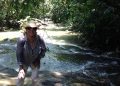 Ropa de mujer en el río en la jungla tropical, explorando la naturaleza, aventura y turismo ecológico, mujer caminando, flora y agua, obstáculos en la naturaleza, vida silvestre.