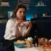 Comida para llevar, mujer comiendo comida rápida con comida chatarra y bebida en un ambiente moderno y acogedor.