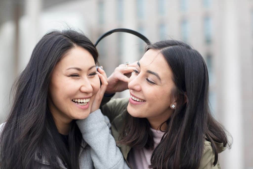 Chicas sonriendo, amistad, diversidad cultural, mujeres felices, relación social, alegría y compañerismo, imágenes de amistad, mujer latina y mujer caucásica, conexión entre mujeres, sonrisa y felicidad, cultura y comunidad, Revista SoyMigrante.com. – SoyMigrante.com REVISTA