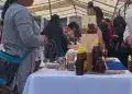 Botella de miel y productos artesanales en stand de feria cultural en un mercado al aire libre. – SoyMigrante.com REVISTA