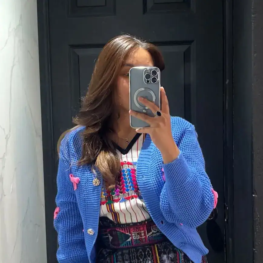 Soy-migrante-mujer-auténtica-vestido-colorido-vestimenta-tradicional, revistaporte, fotografía de una mujer con ropa tradicional mexicana, tomada en un espejo, reflejada en fondo oscuro. – SoyMigrante.com REVISTA