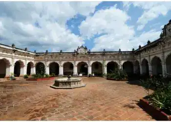 Jardín histórico en una hacienda colonial mexicana con arquitectura clásica y cielo con nubes, ideal para turismo y cultura.