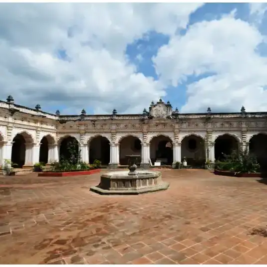 La antigua sede de la Universidad de San Carlos en Antigua Guatemala – SoyMigrante.com REVISTA Jardín histórico en una hacienda colonial mexicana con arquitectura clásica y cielo con nubes, ideal para turismo y cultura. – SoyMigrante.com REVISTA