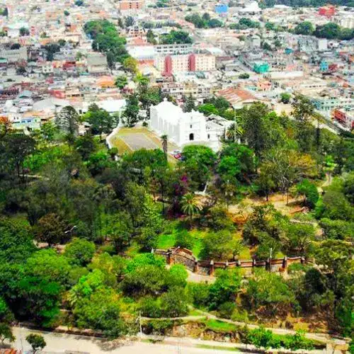 Catedral de Xalapa rodeada de espacios verdes y áreas recreativas en un parque urbano en la ciudad de Xalapa, Veracruz, México. Jardines, senderos y árboles destacan en esta vista panorámica de la naturaleza urbana. – SoyMigrante.com REVISTA