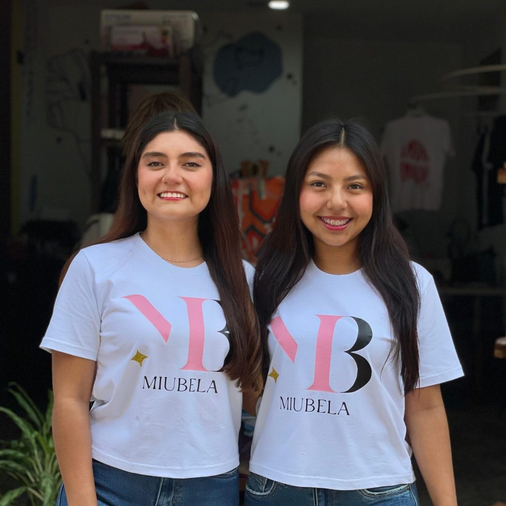Jóvenes emprendedoras mexicanas con camisetas de Mueblea, en un entorno urbano, promoviendo el talento latino y la moda ecológica, en el marco de una campaña de empowering para mujeres emprendedoras. – SoyMigrante.com REVISTA