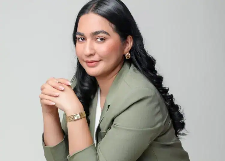 Profesional mujer inmigrante con estilo, cabello oscuro y blazer verde, reflejando liderazgo y confianza. Imagen adecuada para artículos sobre migración, derechos y experiencias de inmigrantes en la revista SoyMigrante.com REVISTA.