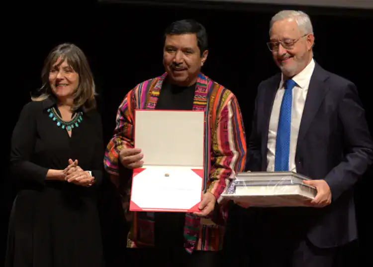 Reconocimiento y entrega de premios en evento cultural de SoyMigrante.com Revista presentando figuras destacadas de la migración.