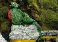 Rana de piedra decorativa en entorno natural con señal de bienvenida en México, símbolo cultural y turístico para visitantes y migrantes.
