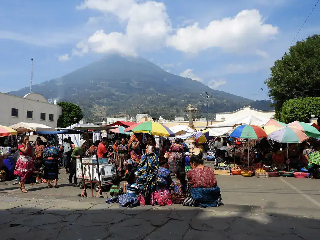 Vendedor ambulante en mercado tradicional en México, con volcán en fondo, población local, ambiente cultural, comercio y vida cotidiana, imágenes de mercado popular mexicano. – SoyMigrante.com REVISTA