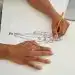 Dibujo de moda de una persona con ropa elegante siendo ilustrada a mano en papel para revista de moda.