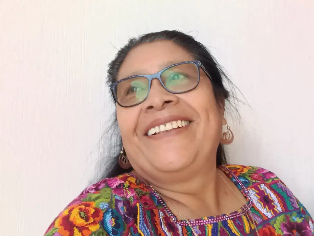 Amiga sonriendo con gafas y ropa colorida, foto para revista SoyMigrante.com REVISTA, destacando migrantes hispanohablantes y cultura mexicana, imagen para contenido de interés social e migratorio en Latinoamérica. – SoyMigrante.com REVISTA