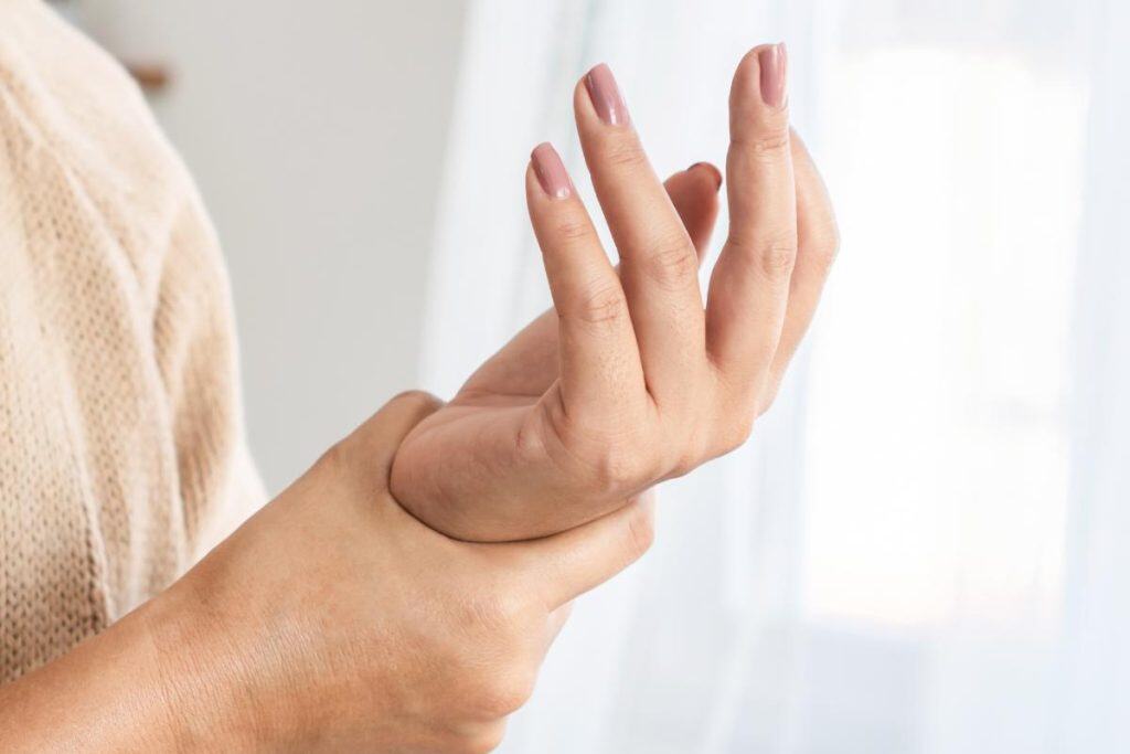 Alto: Mujer recibiendo un masaje en la mano en un ambiente luminoso y relajante, promoviendo bienestar y cuidado personal, enfoque en salud, relajación y terapia manual. – SoyMigrante.com REVISTA