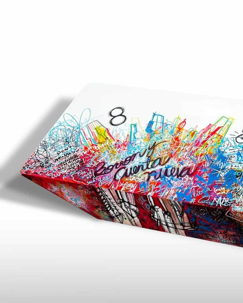 Colorido cubo de Rubik decorado con grafitis y frases relacionadas con inmigrantes y migración.