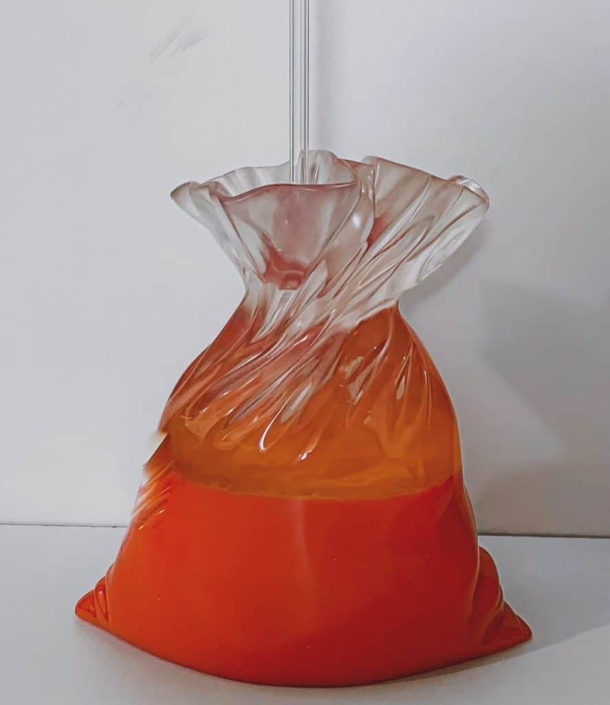 Vidrio decorativo artesanal con forma de flor en tonos anaranjados y transparentes, ideal para decoración moderna y elegante en interiores.