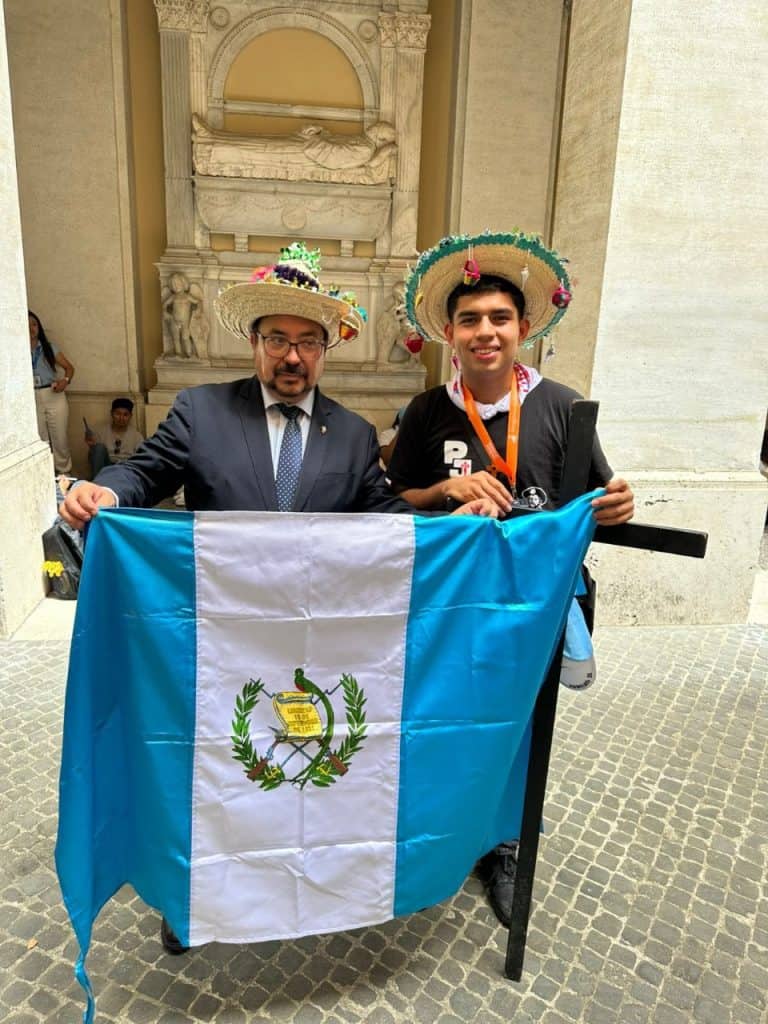 Guatemaltecos en evento cultural con bandera y sombreros tradicionales en un lugar histórico. – SoyMigrante.com REVISTA