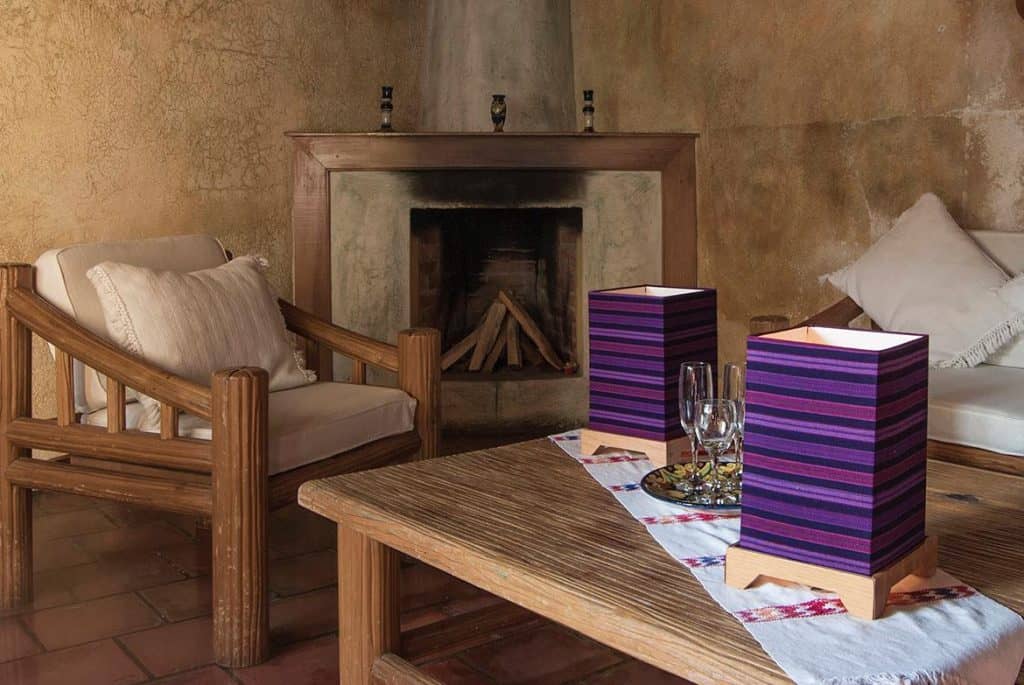 Acogedora sala con chimenea, muebles de madera y decoración cálida, ideal para disfrutar de momentos de descanso en un ambiente tradicional y confortable.