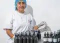 Botellas de productos cosméticos en un laboratorio de fabricación, mujer trabajando con ética en el sector cosmético, innovación en la industria de belleza para emigrantes en Latinoamérica.