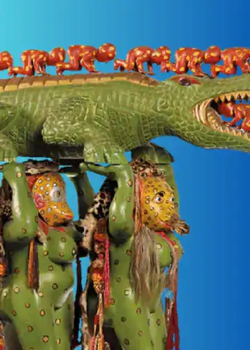 Cultura indígena con figuras de animales y personajes tradicionales en una escultura colorida para promover el arte y la tradición en La revista SoyMigrante. – SoyMigrante.com REVISTA