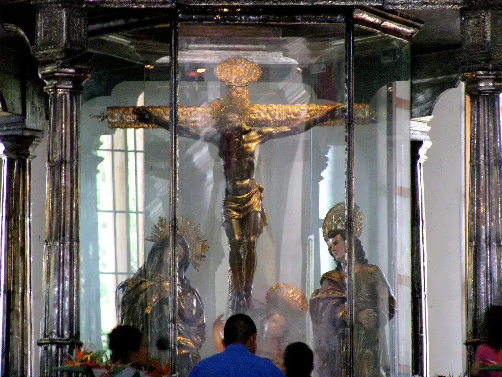 Cristo de la Catedral de Antigua Guatemala en exhibición dentro de una vitrina, acompañado por figuras religiosas y un entorno histórico que refleja la riqueza cultural y religiosa de la región. – SoyMigrante.com REVISTA