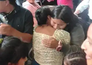 Abrazo de consuelo entre migrantes en centro de encuentro, demostrando solidaridad y apoyo mutuo en momentos difíciles. Imagen emotiva que refleja empatía y unión en comunidad migrante.