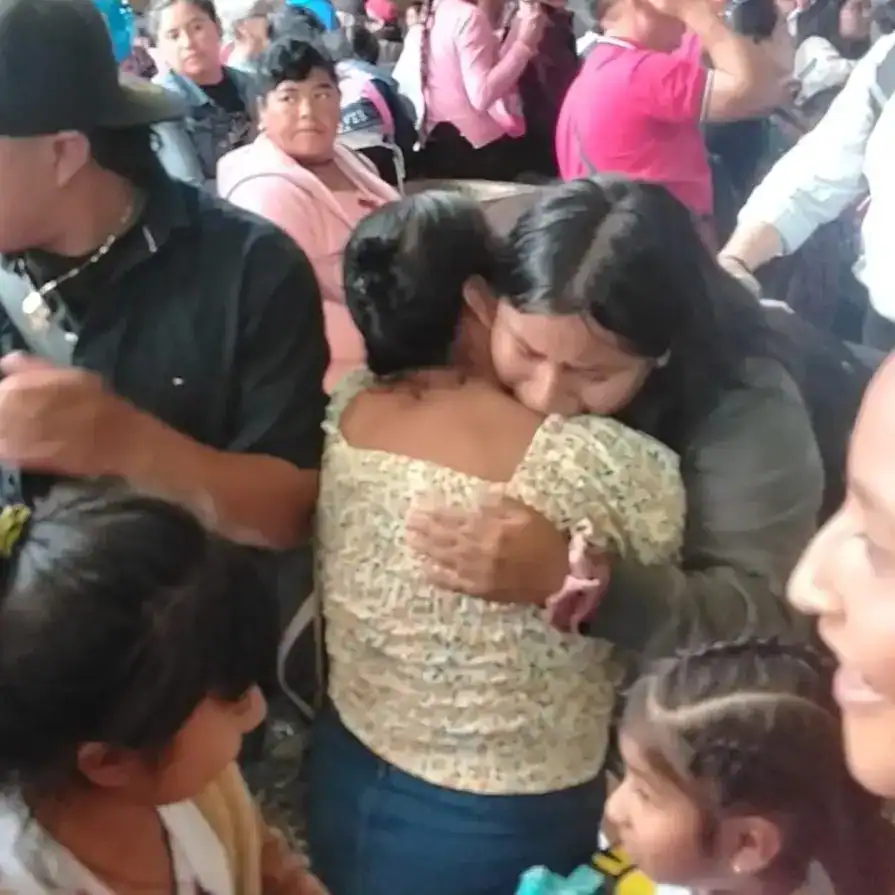 Abrazo de consuelo entre migrantes en centro de encuentro, demostrando solidaridad y apoyo mutuo en momentos difíciles. Imagen emotiva que refleja empatía y unión en comunidad migrante.