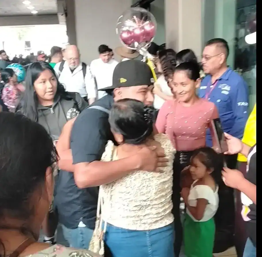 Felicitación y abrazos en evento de migrantes en SoyMigrante.com REVISTA, celebración de comunidad migrante en un espacio público con interacción y alegría. – SoyMigrante.com REVISTA