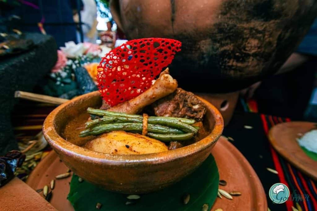 Arraial de comida tradicional mexicana en un plato de barro con guarniciones y decoración cultural. – SoyMigrante.com REVISTA
