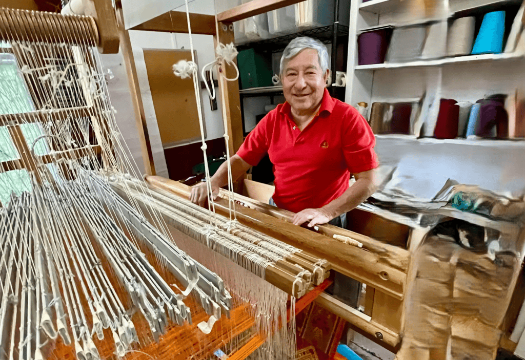 Artesano fabricando tapices en taller de tejidos tradicionales con telar manual para mantener viva la cultura textil. – SoyMigrante.com REVISTA