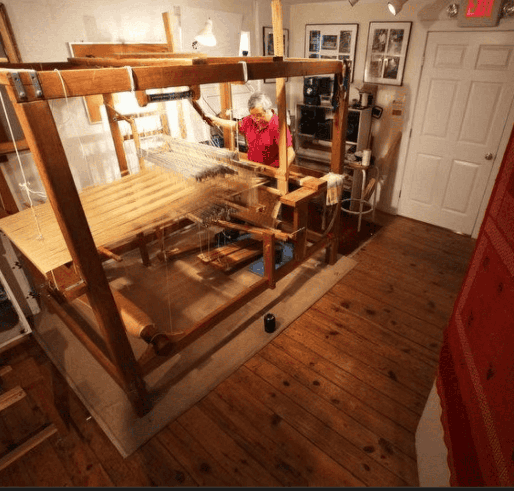 Tejedora artesanal trabajando en telar tradicional en un taller cultural. – SoyMigrante.com REVISTA