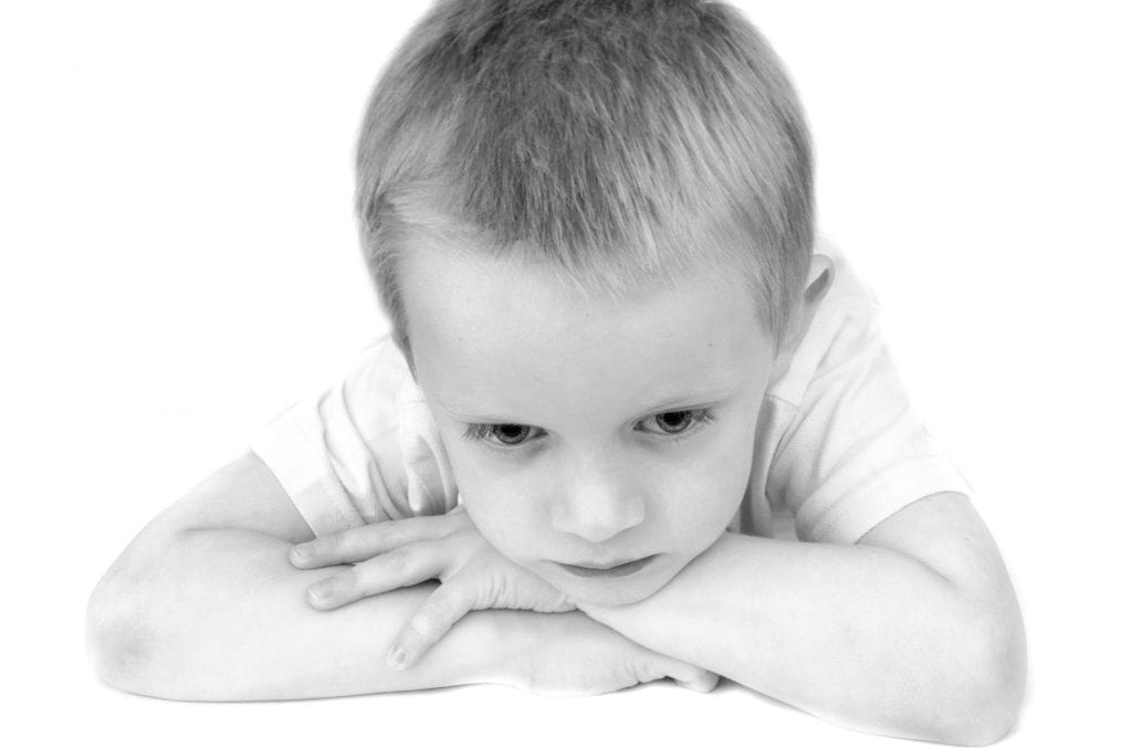 Sanar las heridas del pasado es algo que te ayudará para el futuro. (Foto: Envato) – SoyMigrante.com REVISTA Niño contemplando pensativo, expresión reflexiva en un primer plano en blanco y negro para revista SoyMigrante.com. – SoyMigrante.com REVISTA