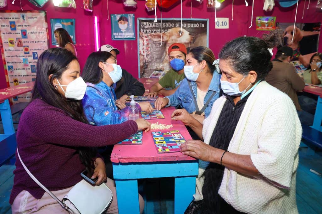 Jugar a la Oca en familia en un ambiente colorido y alegre, participando en actividades educativas y recreativas en un espacio dedicado a la cultura migrante y comunidad local en el evento de SoyMigrante.com. – SoyMigrante.com REVISTA
