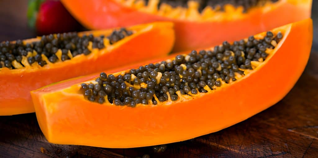 Sabrosa papaya con semillas negras frescas, fruta tropical saludable y nutritiva para artículos sobre migrantes y cultura en Revista SoyMigrante. – SoyMigrante.com REVISTA