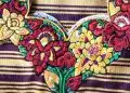 Colorido bordado de flores tradicionales mexicanas, representando la riqueza cultural y artística en la revista SoyMigrante.com REVISTA. Diseño vibrante que resalta el folclore y la identidad mexicana en el contexto migratorio.